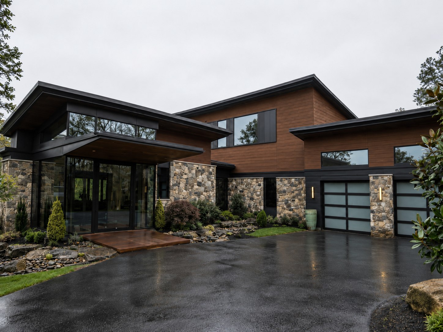 Haymarket entry nearing completion — covered entry, stone, warm wood, and glass beneath a floating roof, with frameless glass garage doors