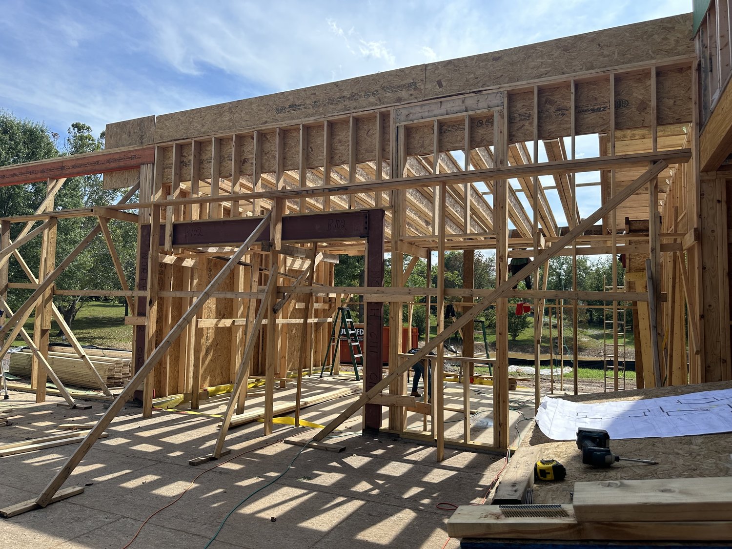 Haymarket under construction — heavy wood framing and steel beams under a blue sky