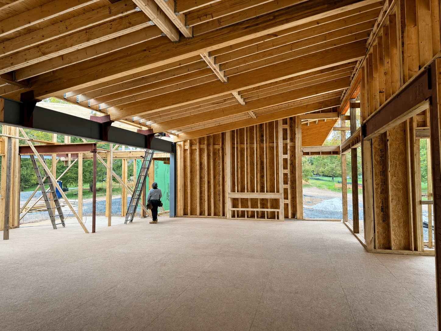 Interior of Haymarket during framing — exposed wood ceiling structure and full-height window openings