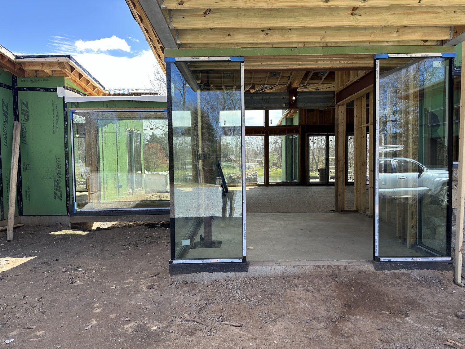 Haymarket envelope — green ZIP System sheathing with large glass walls installed